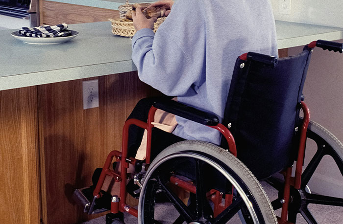 Person in a wheelchair at a kitchen counter, illustrating real-life moments related to school gossip facts exposed.