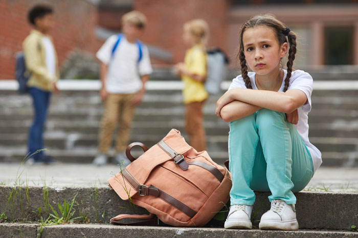 Teen feels like prisoner babysitting autistic sister, sitting alone on steps with backpack, looking upset and isolated. Teen feels like prisoner babysitting autistic sister, sitting alone on steps with backpack, looking upset and isolated.