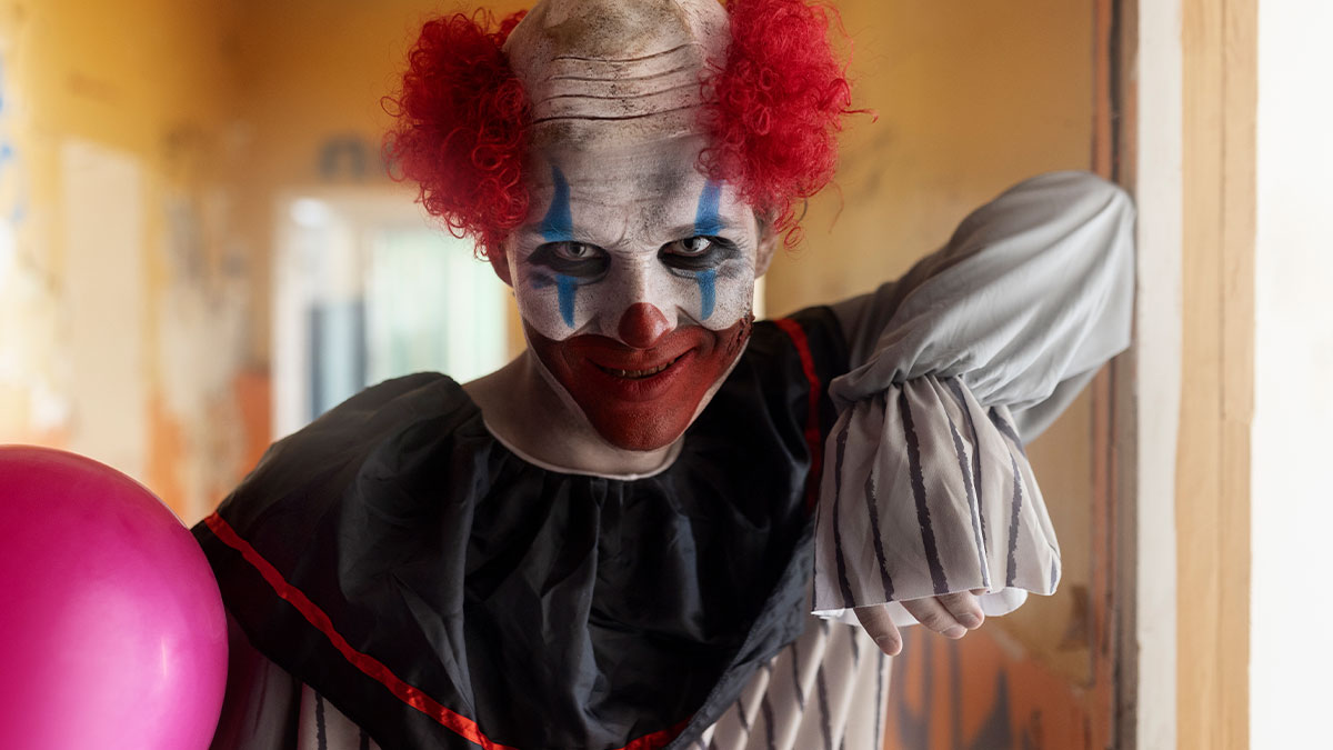 Creepy clown costume with red wig and face paint popping out of the dark to scare mother-in-law away at night.