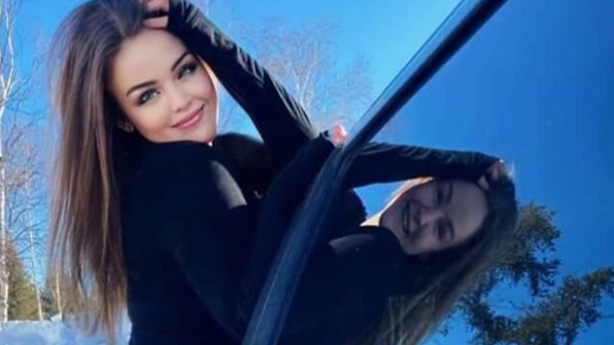 Young woman posing next to a car window reflecting her face, illustrating failed social media filter attempts outside.