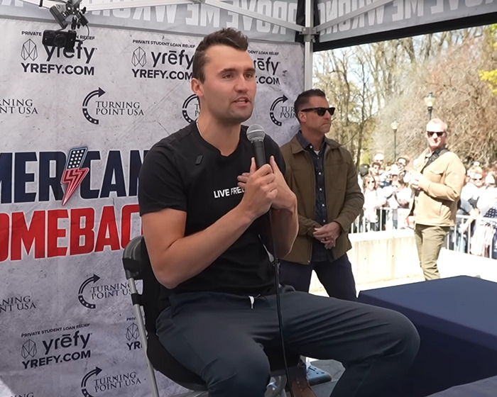 Man speaking into a microphone at an outdoor event with a South Park viewers enraged over eerie episode theme. Man speaking into a microphone at an outdoor event with a South Park viewers enraged over eerie episode theme.