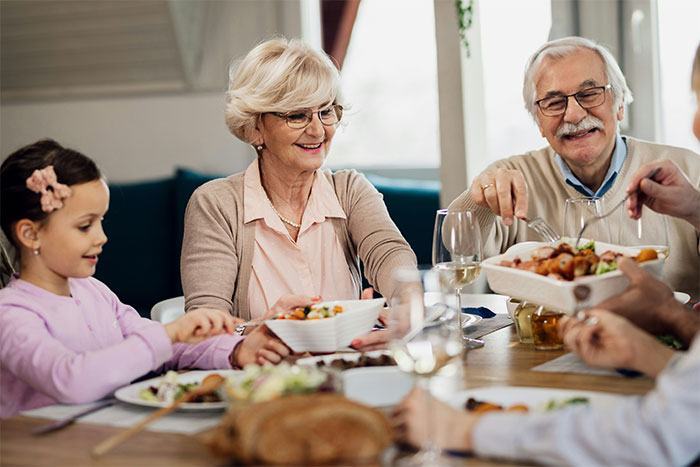 Elderly couple and child sharing a meal at the table, illustrating unusual ways people found out their partner was cheating.