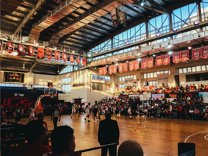 Basketball game in a crowded gym with spectators watching players, illustrating unhinged ways people found out cheating.