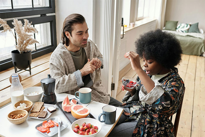 Couple having tense breakfast at home, illustrating crazy and unhinged ways people found out their partner was cheating.
