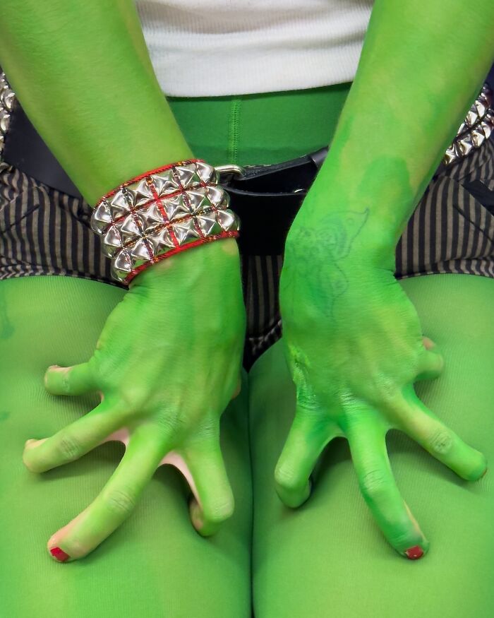Green-painted hands with red nail polish and a silver-studded bracelet, showcasing unique things people carry on the subway.