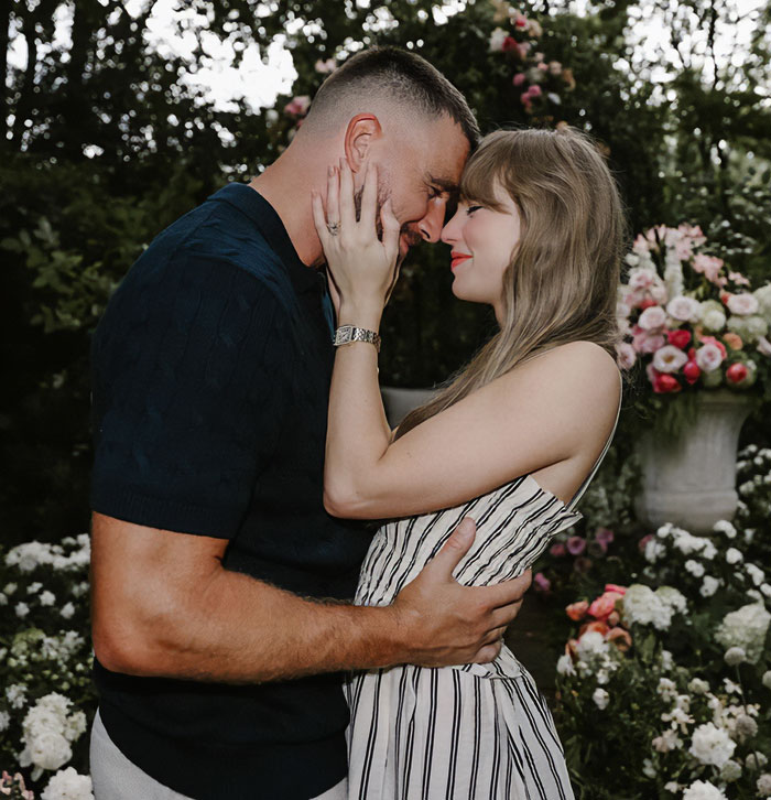 Couple embracing outdoors surrounded by flowers, illustrating a moment connected to Taylor Swift wedding discussion. Couple embracing outdoors surrounded by flowers, illustrating a moment connected to Taylor Swift wedding discussion.
