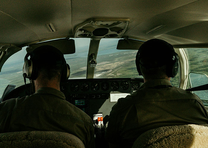 Two pilots wearing headsets inside a small airplane cockpit during flight, illustrating family drama with plane refusal. Two pilots wearing headsets inside a small airplane cockpit during flight, illustrating family drama with plane refusal.
