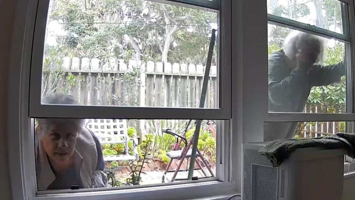 Two landlords outside a window peering inside, illustrating horrible landlord behavior renters want to avoid.