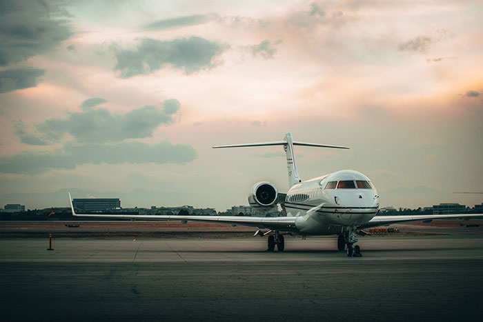 Private jet parked on an airport runway under a cloudy sky, illustrating scenes relentlessly pursued by someone in movies.