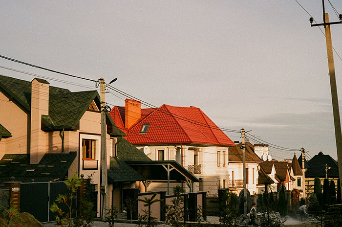 Row of suburban houses with varied roofs and power lines, illustrating things that look awesome in movies but are terrible in real life.