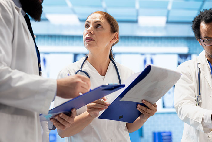 Doctors in white coats reviewing medical charts, illustrating things that look awesome in movies but are terrible in real life.