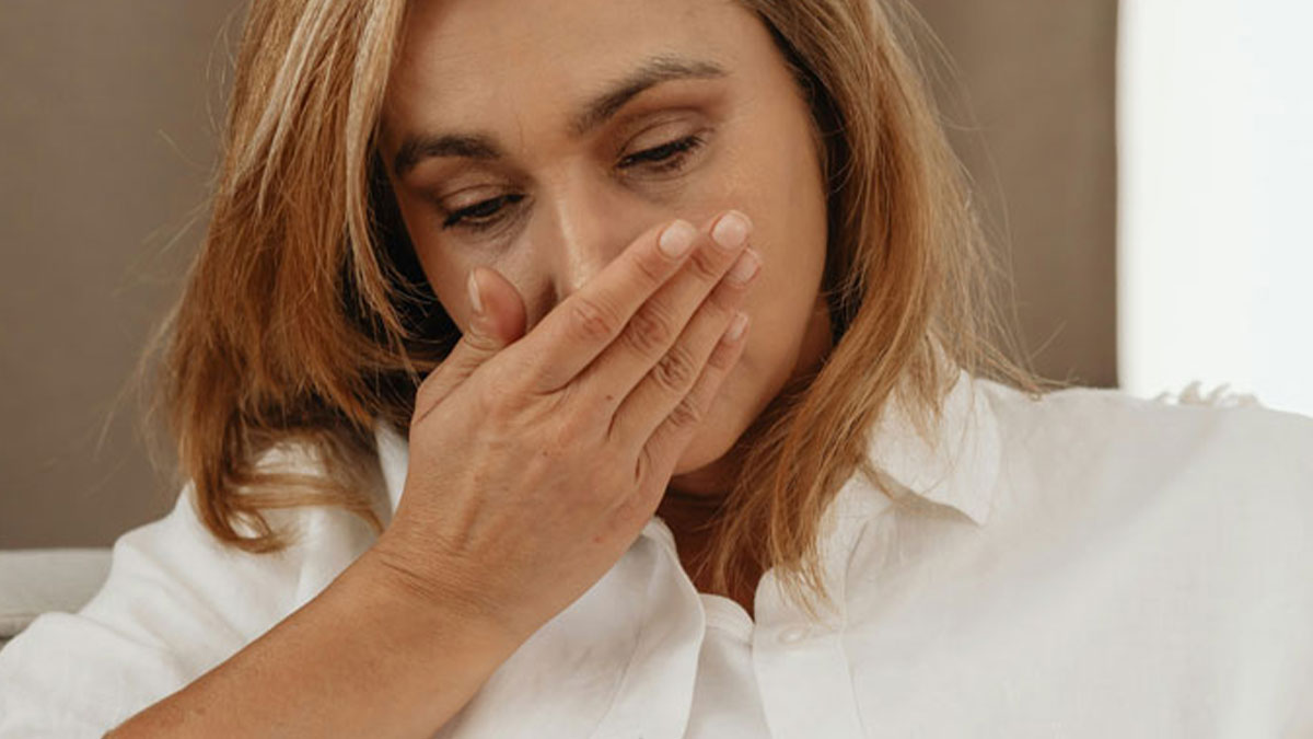 Woman covering mouth with hand, showing disgust after a glance at a phone causing instant ick reaction and discomfort.