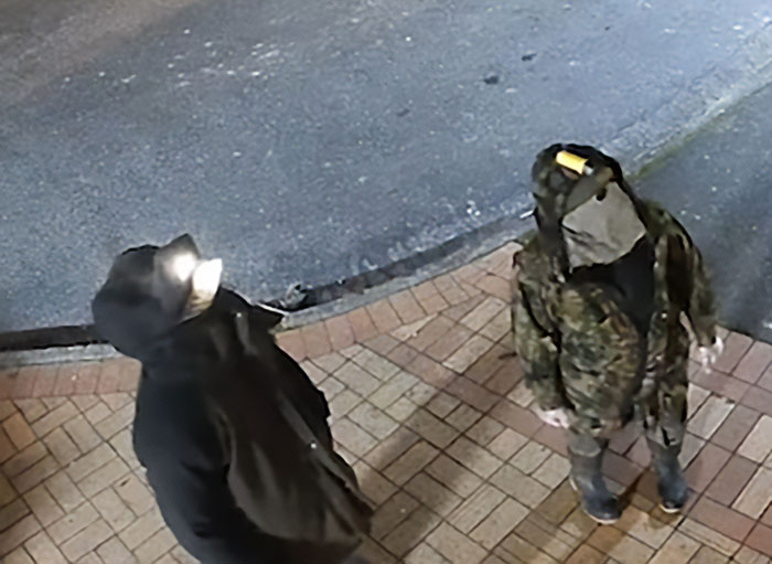 Two individuals dressed in dark outdoor clothing near a road, related to kids who vanished into wilderness case. Two individuals dressed in dark outdoor clothing near a road, related to kids who vanished into wilderness case.