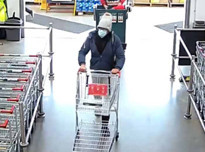 Person wearing a mask and hat pushing a shopping cart inside store related to mom of kids who vanished into wilderness news. Person wearing a mask and hat pushing a shopping cart inside store related to mom of kids who vanished into wilderness news.