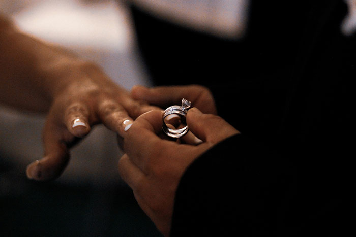 Close-up of a woman’s hand receiving a ring during a ceremony, reflecting a woman remarry upset about a cheater ex. Close-up of a woman’s hand receiving a ring during a ceremony, reflecting a woman remarry upset about a cheater ex.