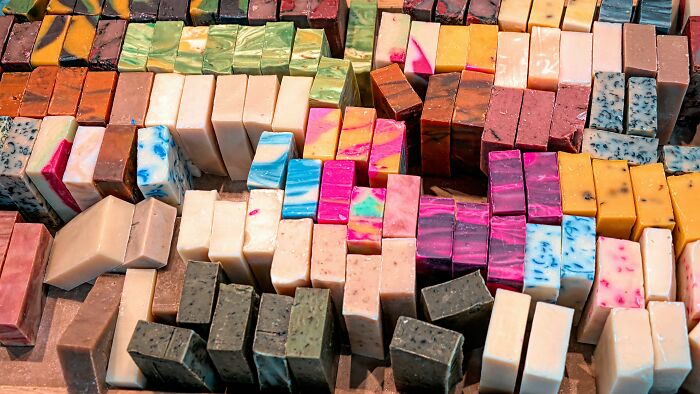 Colorful handmade soap bars arranged in rows, unrelated to butcher and gravedigger professions raising suspicion.