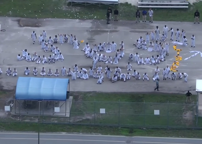 Aerial view of detainees at Alligator Alcatraz facility gathered outdoors, highlighting concerns about missing ICE records. Aerial view of detainees at Alligator Alcatraz facility gathered outdoors, highlighting concerns about missing ICE records.