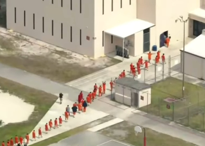 Detainees in orange uniforms walking in line inside a secured facility missing from ICE records after Alligator Alcatraz transfer Detainees in orange uniforms walking in line inside a secured facility missing from ICE records after Alligator Alcatraz transfer
