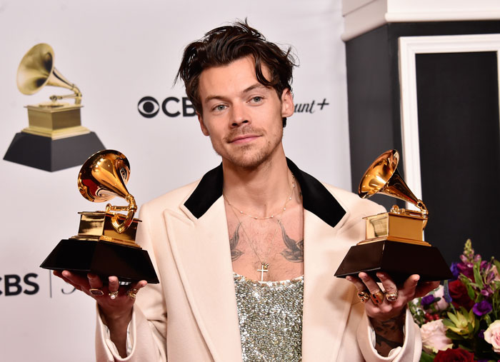 Harry Styles holding two Grammy awards, recognized for secretly running Berlin marathon with impressive speed. Harry Styles holding two Grammy awards, recognized for secretly running Berlin marathon with impressive speed.