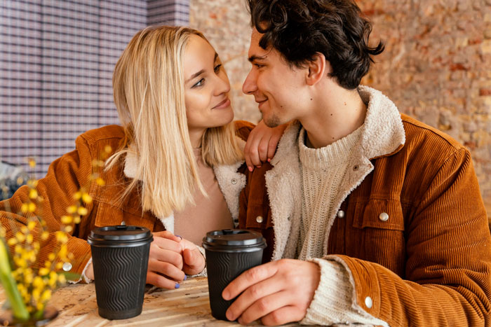 Couple enjoying coffee date inside café while discussing allergies and rigid café rules affecting their visit. Couple enjoying coffee date inside café while discussing allergies and rigid café rules affecting their visit.