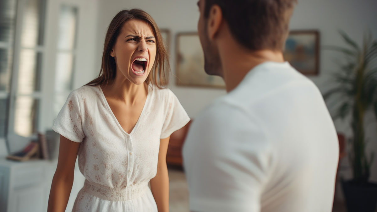 Young woman angrily confronting a man indoors, highlighting confrontation and fear of divorce after coworkeru2019s comment.