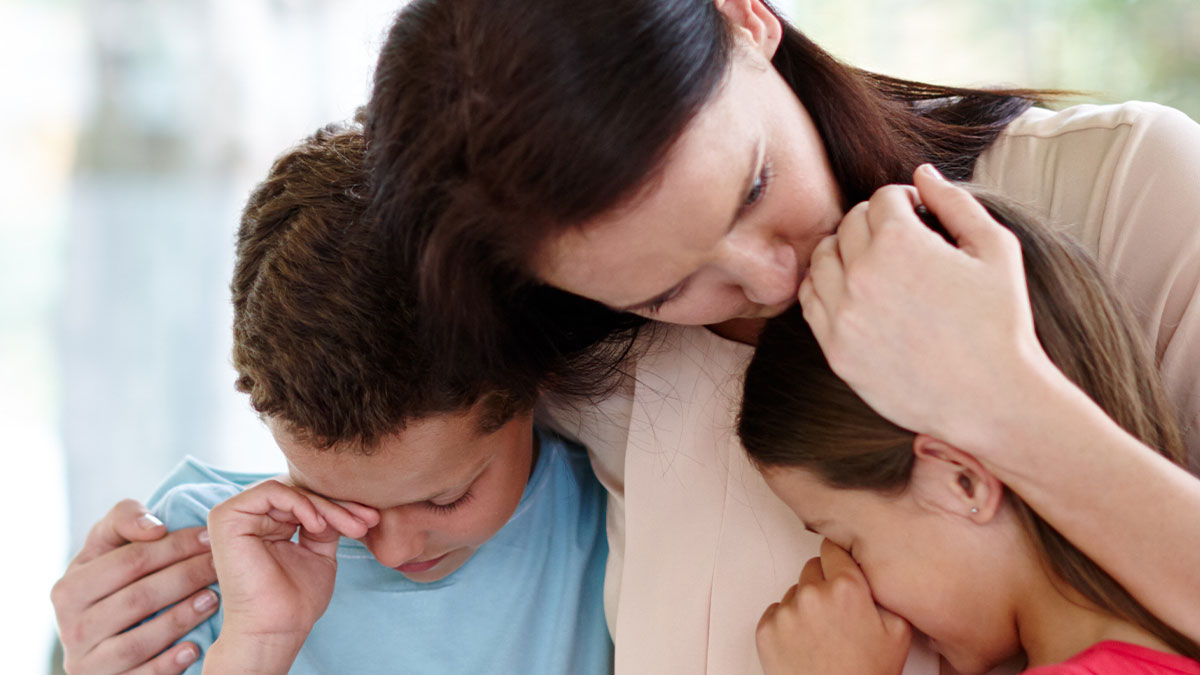 Woman comforting two children, illustrating a womanu2019s life turning upside down after her late sisteru2019s dying wish.