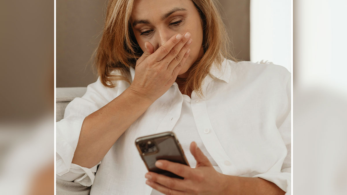 Woman upset and emotional looking at her phone, reflecting on feelings related to a cheater ex and remarriage.