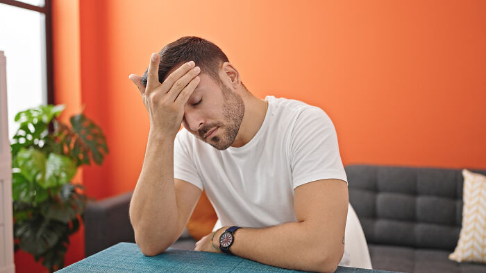 Young man in a white shirt looking stressed, representing sewer workers encountering bizarre things while working down there.