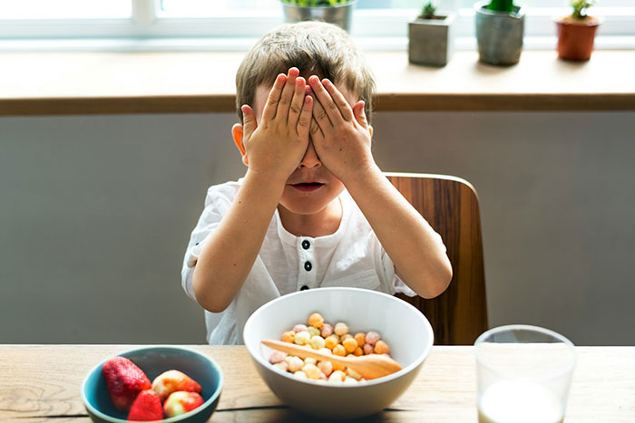 Young teen covering face in kitchen after cake fail, expressing disappointment in dad’s care and attention. Young teen covering face in kitchen after cake fail, expressing disappointment in dad’s care and attention.