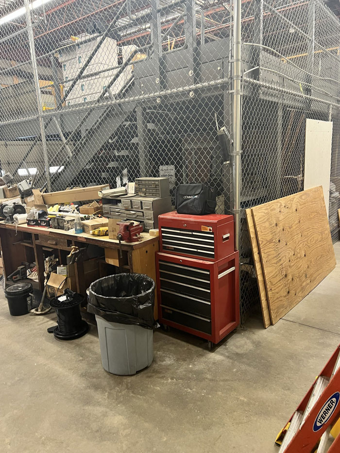 Workshop area with red tool chest and cleaning supplies, part of a coworker’s office frozen in grime cleanup task Workshop area with red tool chest and cleaning supplies, part of a coworker’s office frozen in grime cleanup task