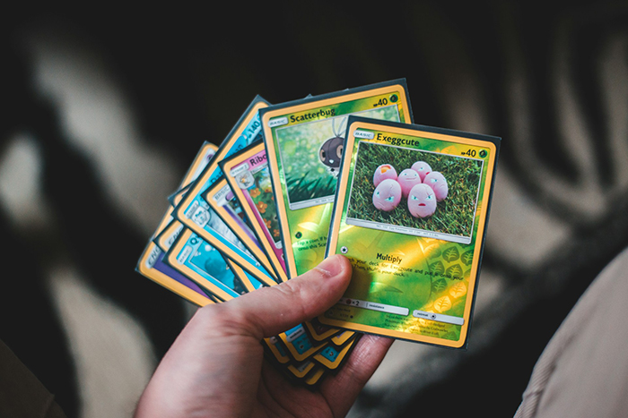 Hand holding a collection of Pokémon cards, highlighting the husband's valued Pokémon card collection controversy. Hand holding a collection of Pokémon cards, highlighting the husband's valued Pokémon card collection controversy.