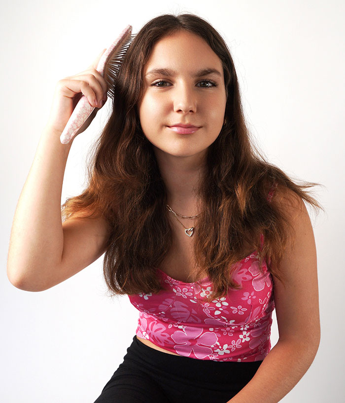 Ein junges Mädchen in einem rosa geblümten Oberteil kämmt sich die Haare und stellt eine 12-Jährige dar, die beim Subway-Surfen ihr Leben verlor, was im Internet zu Schuldzuweisungen an die Eltern führte. Ein junges Mädchen in einem rosa geblümten Oberteil kämmt sich die Haare und stellt eine 12-Jährige dar, die beim Subway-Surfen ihr Leben verlor, was im Internet zu Schuldzuweisungen an die Eltern führte.