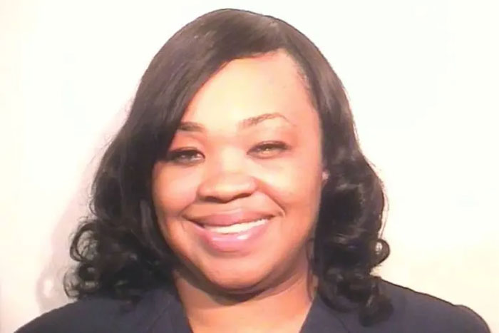 Woman with curled black hair smiling in a close-up portrait related to unhinged act and hospitalization incident. Woman with curled black hair smiling in a close-up portrait related to unhinged act and hospitalization incident.