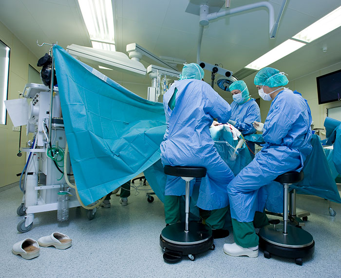 Brain surgeon and surgical team performing a complex procedure in a sterile operating room environment. Brain surgeon and surgical team performing a complex procedure in a sterile operating room environment.