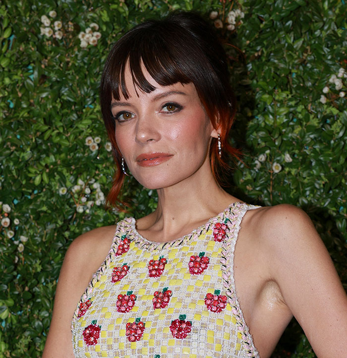 Woman posing in a floral dress with red accents, representing fans clash online over David Harbour cheating controversy. Woman posing in a floral dress with red accents, representing fans clash online over David Harbour cheating controversy.