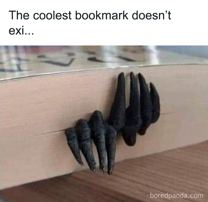 Black claw-shaped bookmark sticking out of a book, a funny and relatable meme for horror and Halloween fans.