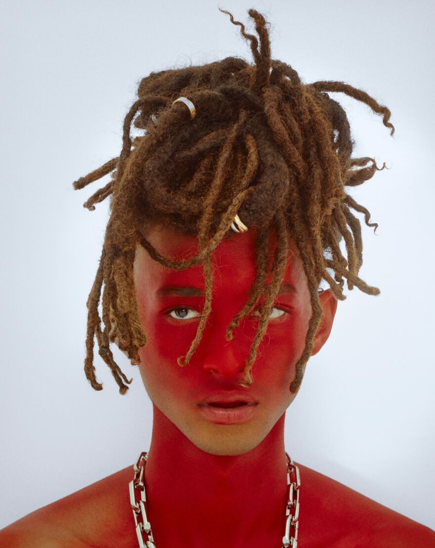 Jaden Smith with dreadlocks and red face paint wearing a silver chain necklace in a studio portrait. Jaden Smith with dreadlocks and red face paint wearing a silver chain necklace in a studio portrait.