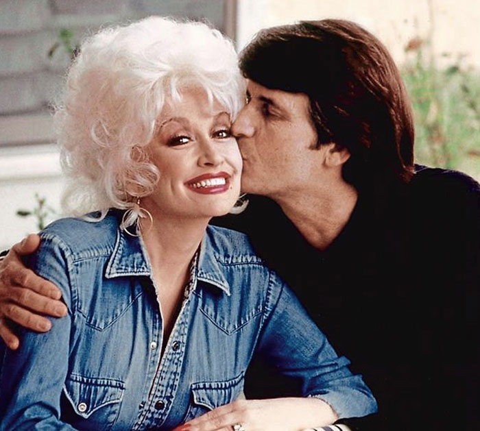 Dolly Parton's sister smiling in denim jacket while receiving a kiss, raising alarm amid singer health struggles. Dolly Parton's sister smiling in denim jacket while receiving a kiss, raising alarm amid singer health struggles.