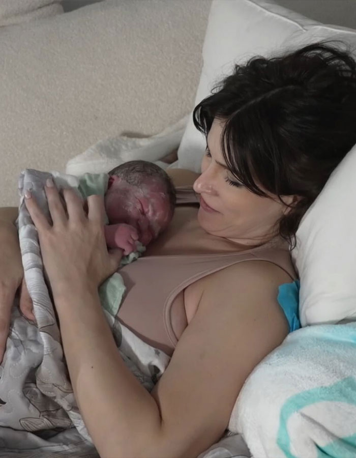 Woman holding newborn baby after giving birth, highlighting birth on Twitch livestream and public reactions. Woman holding newborn baby after giving birth, highlighting birth on Twitch livestream and public reactions.