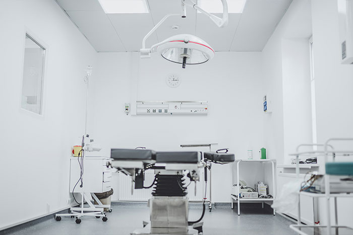 Empty medical examination room with surgical table and bright lighting, related to face tumor urgent help and fatal warning. Empty medical examination room with surgical table and bright lighting, related to face tumor urgent help and fatal warning.