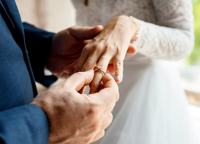 Couple exchanging wedding rings, highlighting wedding sabotaged by parents days before the ceremony in emotional moment.