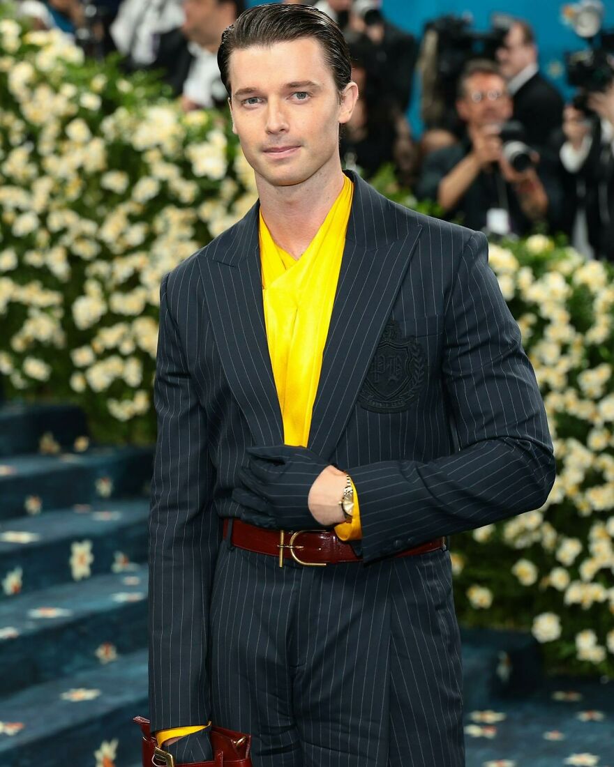 Actor in a pinstripe suit and yellow shirt posing at a red carpet event, representing nepo babies in Hollywood’s new generation. Actor in a pinstripe suit and yellow shirt posing at a red carpet event, representing nepo babies in Hollywood’s new generation.