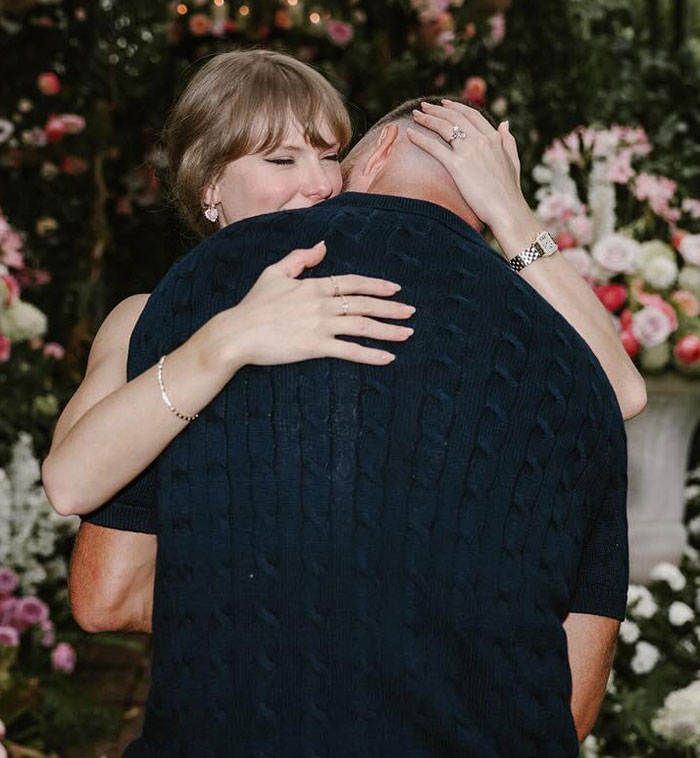 Taylor Swift embracing a man against a floral background, visually unrelated to Graham Norton and Jodie Turner-Smith topics. Taylor Swift embracing a man against a floral background, visually unrelated to Graham Norton and Jodie Turner-Smith topics.
