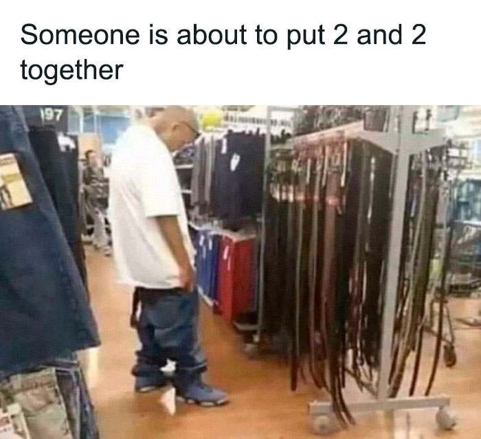 Man in baggy pants and white shirt inside Walmart aisle looking at belts, illustrating a wild People of Walmart moment.