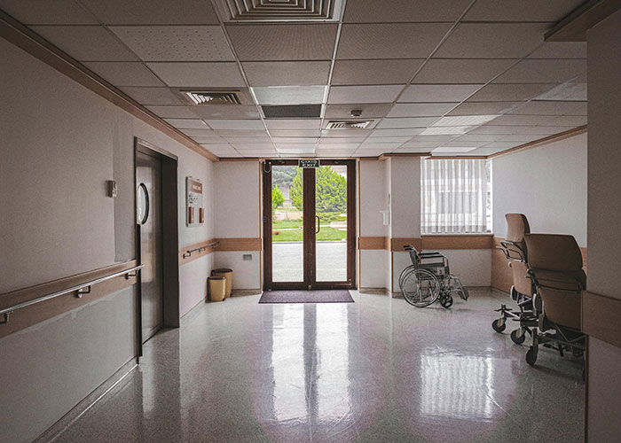 Hospital hallway with wheelchair and medical chairs near glass doors, illustrating mental health myths debunked by psychologists.