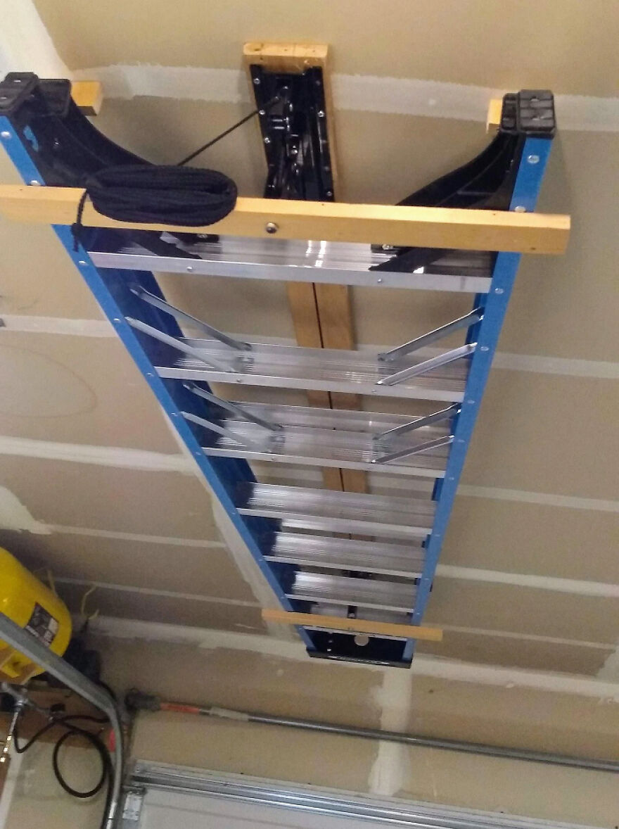 Overhead storage solution with a folded ladder mounted in garage ceiling for space-saving organization hacks at home.