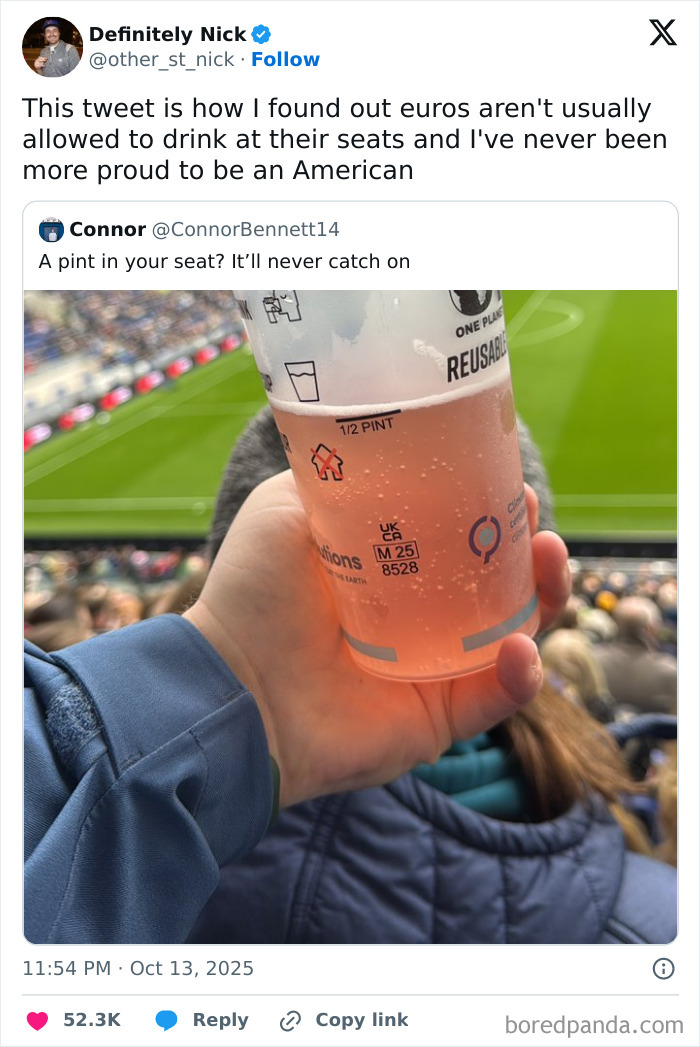 Hand holding a reusable pint cup with drink at a crowded sports stadium, illustrating humorous October tweets.