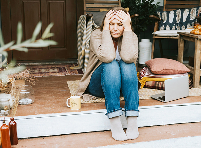 Woman sitting on porch steps looking stressed after business failure, refusing to get a job or have a boss. Woman sitting on porch steps looking stressed after business failure, refusing to get a job or have a boss.