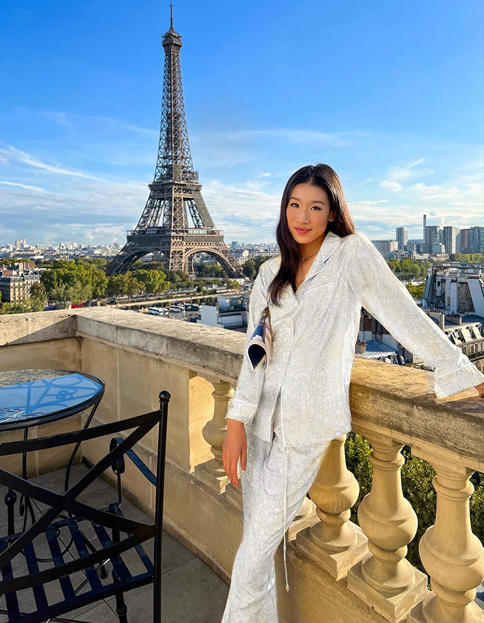 Billionaire influencer posing on balcony with Eiffel Tower, sparking backlash after Hermès shopping haul in Paris. Billionaire influencer posing on balcony with Eiffel Tower, sparking backlash after Hermès shopping haul in Paris.