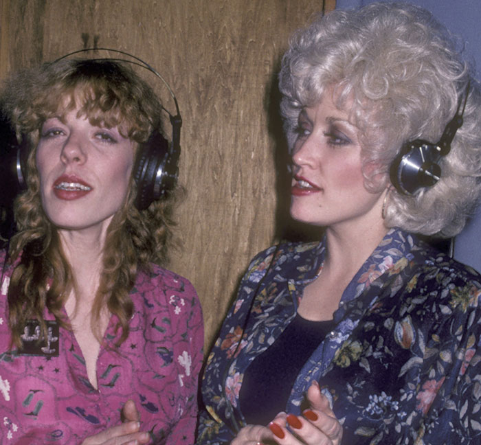 Dolly Parton's sister and Dolly wearing headphones during a recording session amid health struggles concerns. Dolly Parton's sister and Dolly wearing headphones during a recording session amid health struggles concerns.